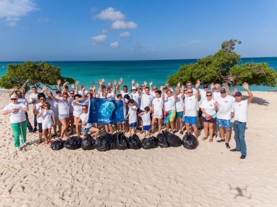 Grupo de personas posando para una foto en la playa cerca de Amsterdam Manor Beach Resort Aruba  