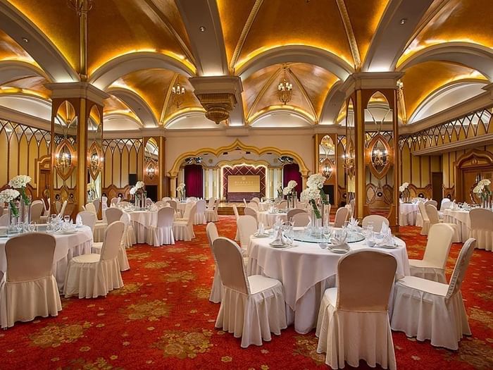 Celebrity Banquet Room with banquets under arched gold ceilings & red floral carpet at Celebrity International Grand Hotel