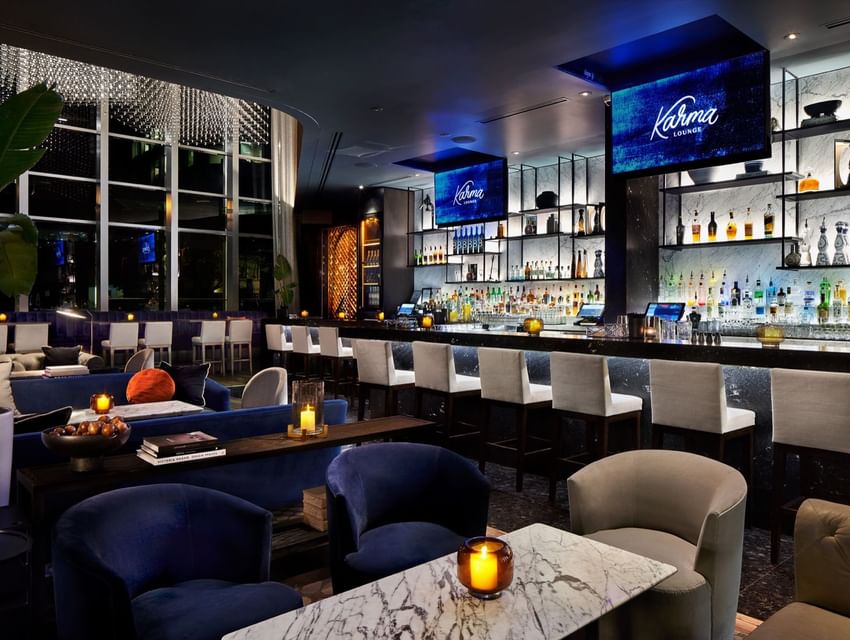 A luxurious lounge with bar, tables, and chairs at Paradox Vancouver.