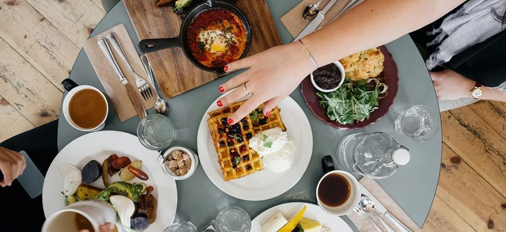 A circular breakfast table with 5 different brunch items.