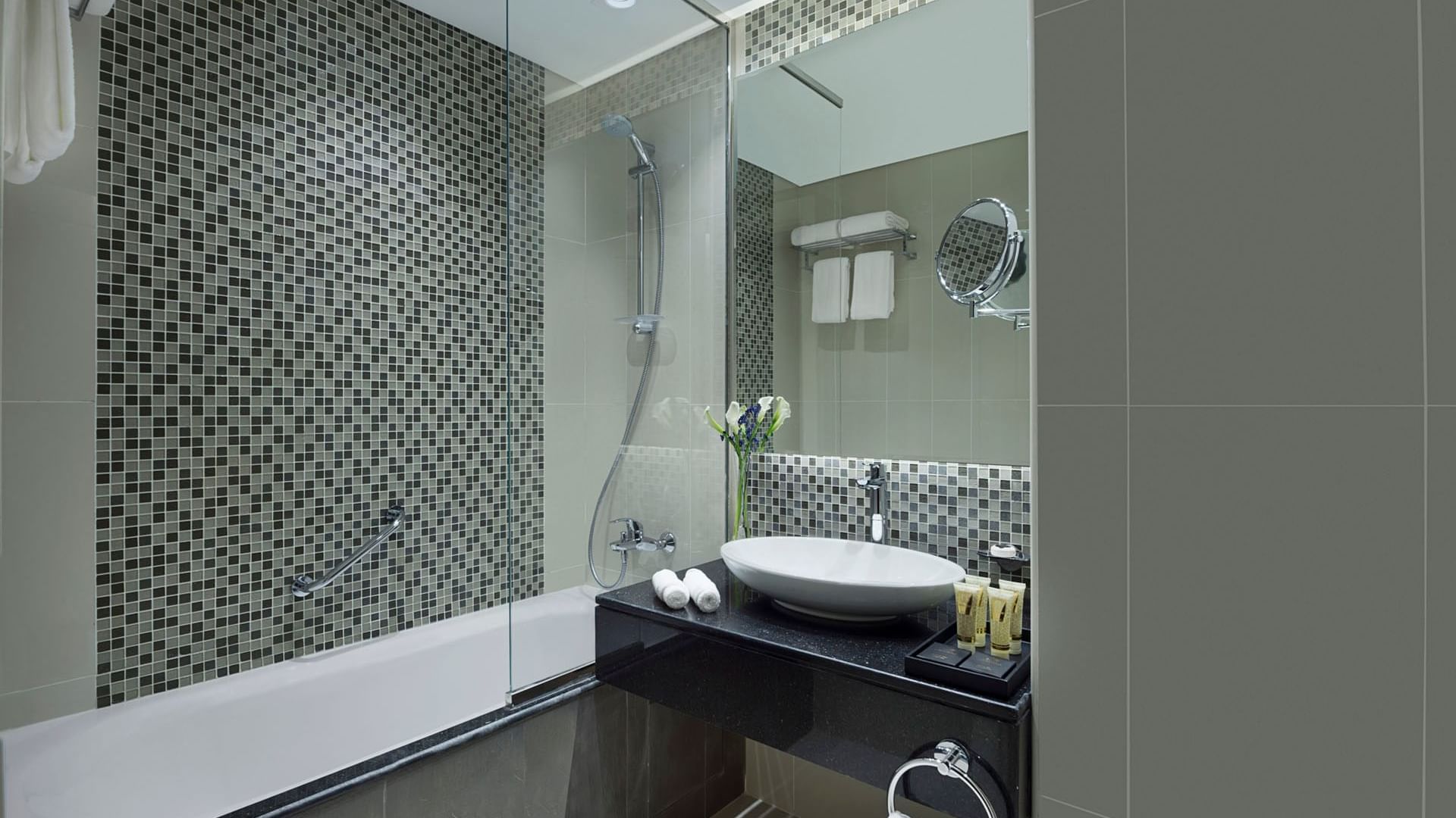 Bathroom vanity with large mirror and provided bathroom amenities in Deluxe Room at DAMAC Maison Distinction