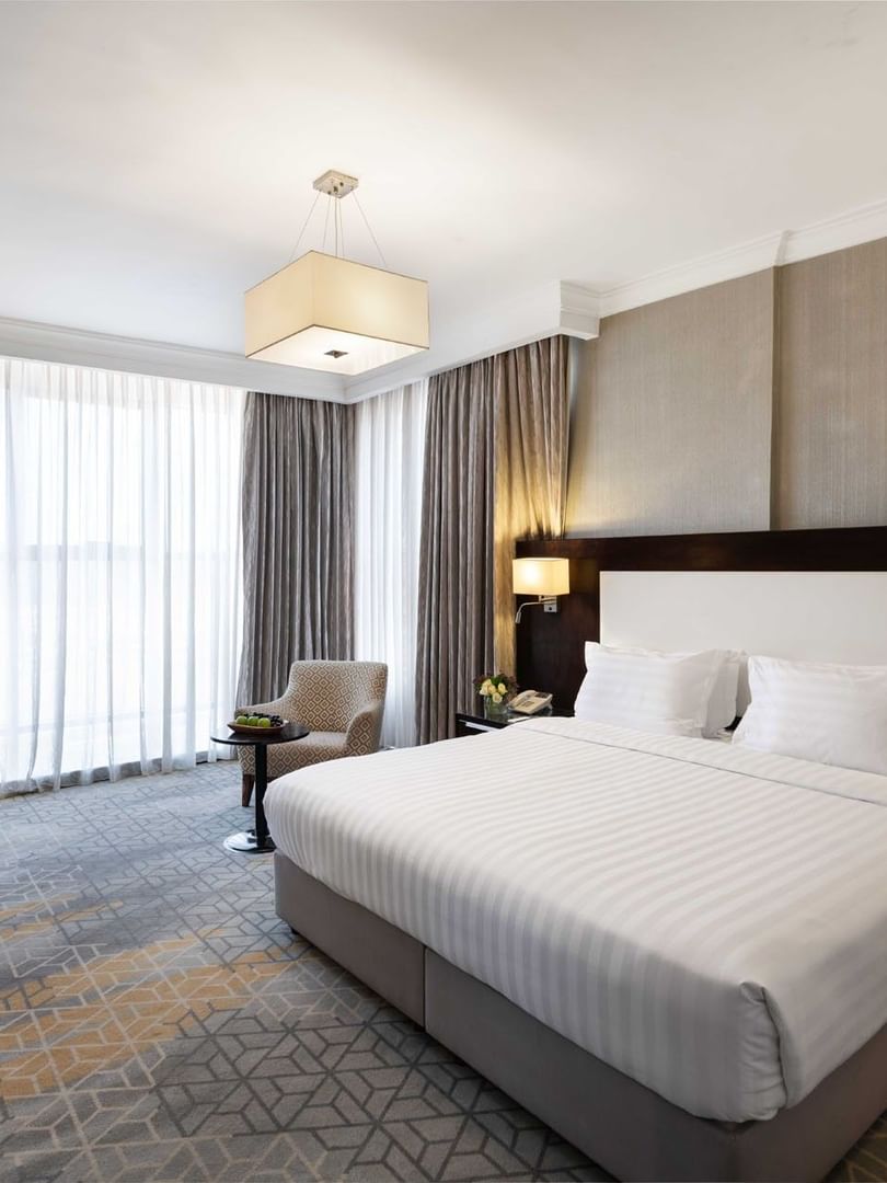 Wall-mounted TV, nightstands, and a work desk by the cozy bed in the Superior Room at Warwick Hotel Jeddah
