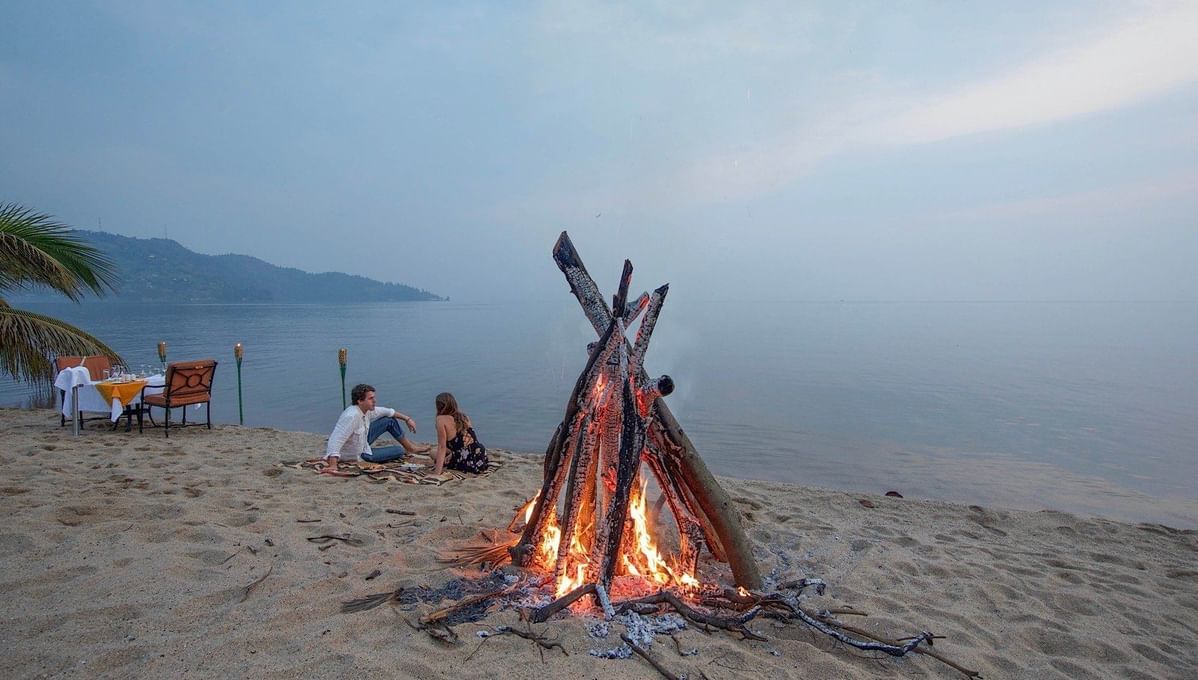 Couple near a bonfire by the lake at Lake Kivu Serena Hotel