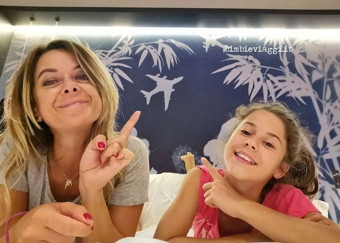 Madre e figlia in posa sorridenti in camera da letto con murale aereoplani e bambù at DUPARC Contemporary Suites