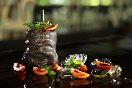 Unique cocktail in a brown mug with a smiling face at Peppers Seminyak