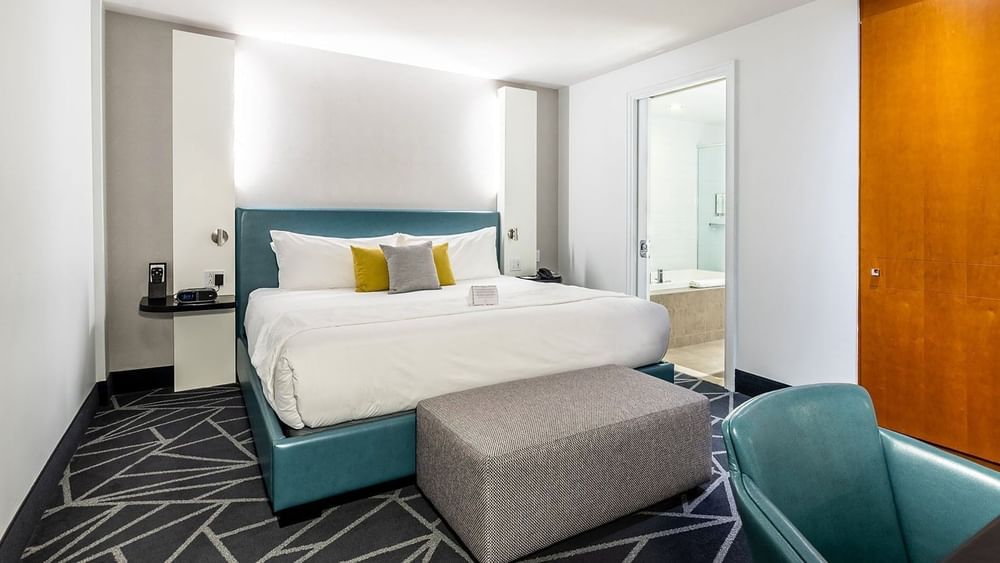 Penthouse Crescent featuring a teal leather bed and work area at Warwick Le Crystal Montreal