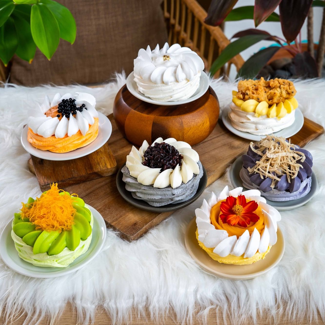 Seven unique Thai-inspired pavlovas displayed on plates atop a table available only at Cafe Studio Karon Beach