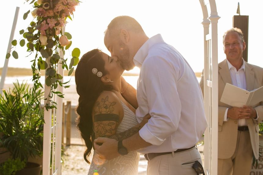 Wedded couple kissing at Thunderbird Beach Resort