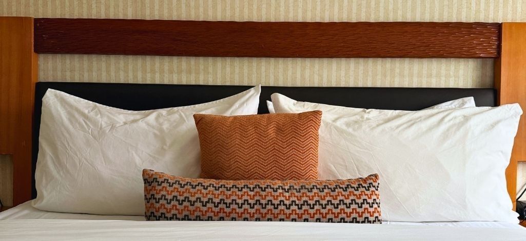 a queen bed with pillows in a guest room at Listel Whistler, a Coast Hotel