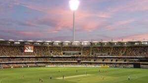 The Gabba cricket field with players and floodlights illuminating the pitch under a colourful sunset near The Sebel Brisbane