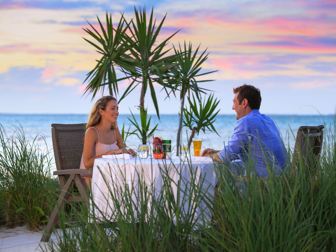 Couple enjoying in Dune Beachside Dining at Windsong Resort On The Reef