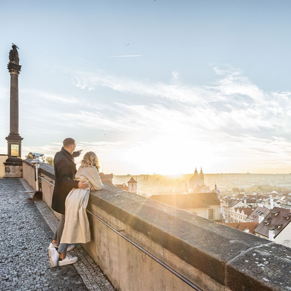 Couple watching the sunset from a balcony at Falkensteiner Hotels