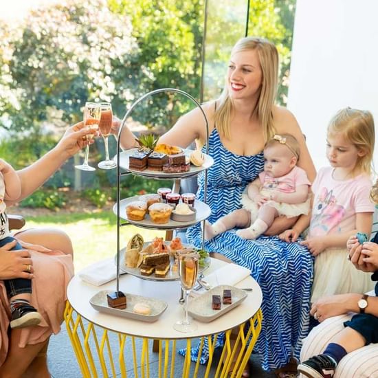 family high tea with variety of cakes and sweets with sparkling wine