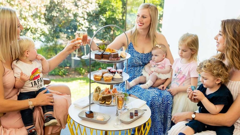 family high tea with variety of cakes and sweets with sparkling wine