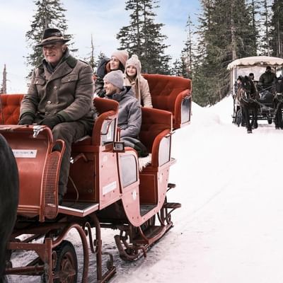 A family on a sleigh ride near Falkensteiner Hotels