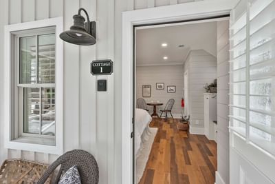 View into Cottage 1 with wooden floors, a mini dining table, and stylish decor by Cottages at Laurel Brooke