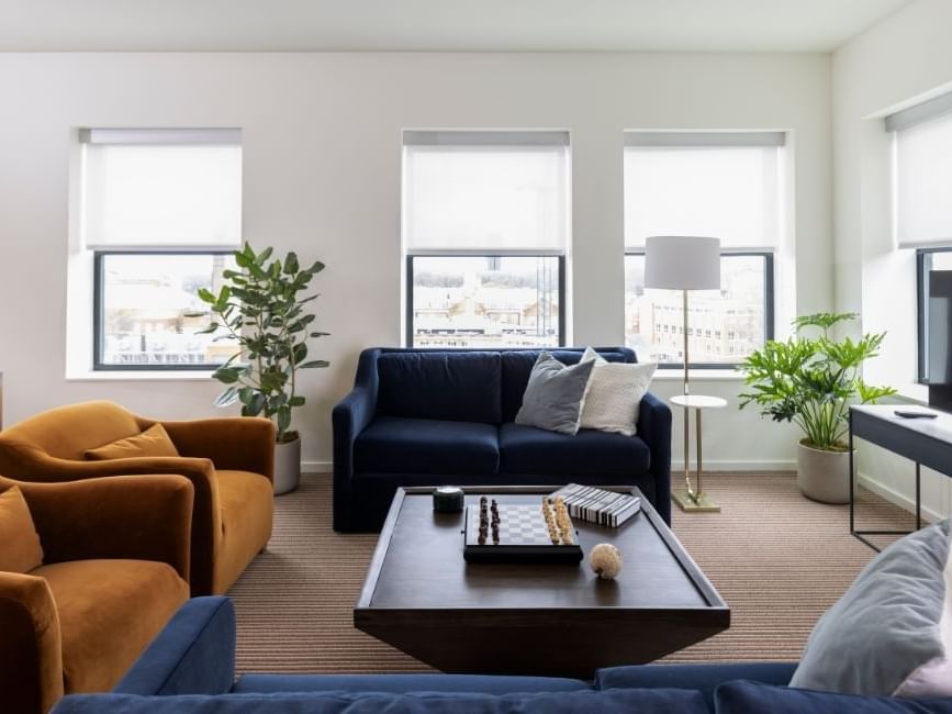The living room of Presidential Suite arranged with cozy sofas & cushioned pillows by TV in The Study Hotel at Johns Hopkins