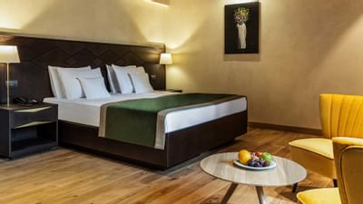 Bed and sofa with wall art in King Balcony at Ana Hotels Bradul