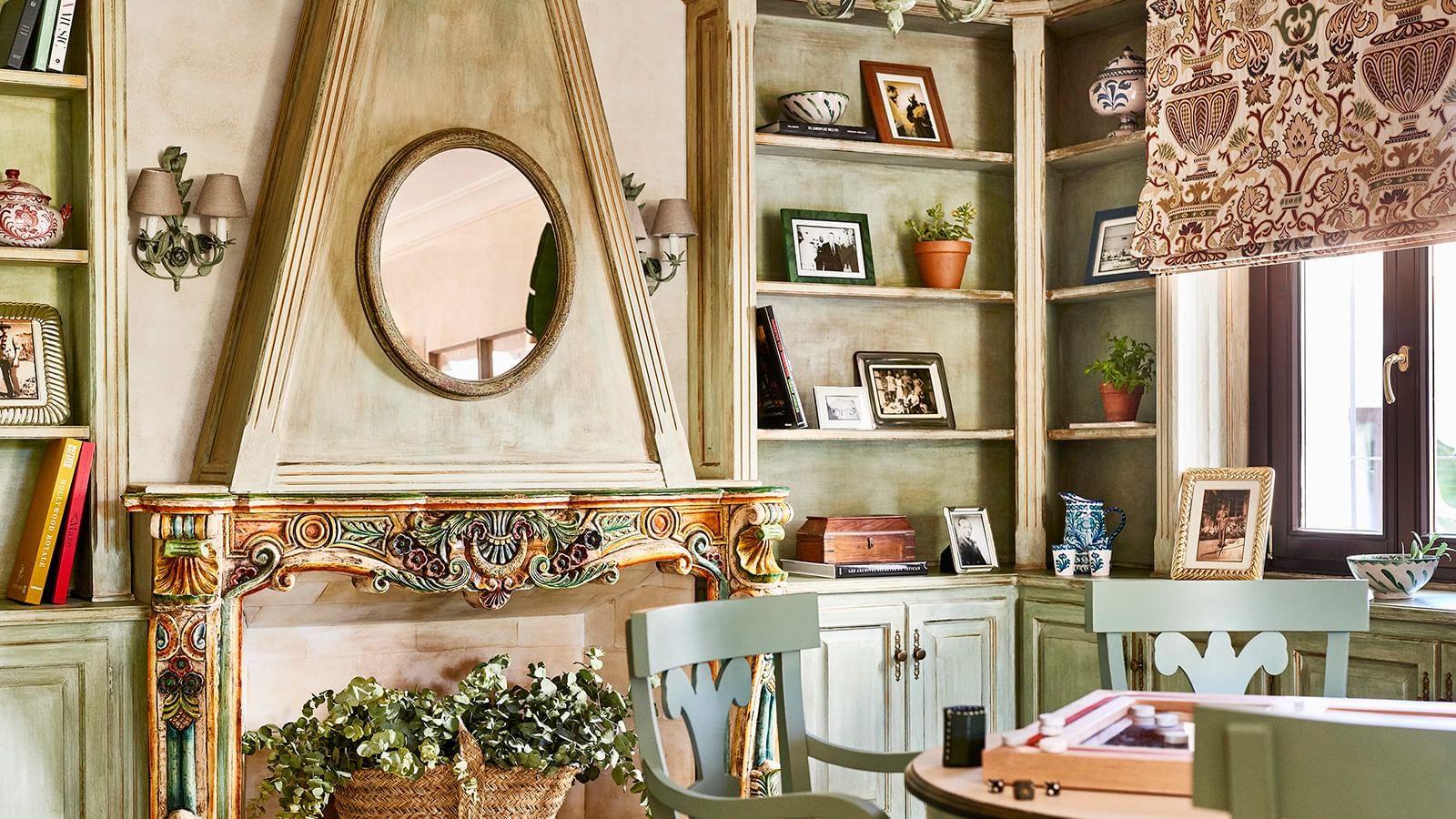 Sitting room with an ornate fireplace near tall, painted, built-in bookshelves at the Marbella Club