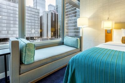 Chaise Lounge by a window facing the city at Kinzie Hotel Room