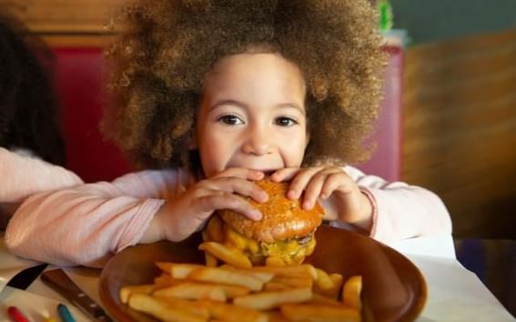 Dukes Steakhouse Childrens Menu featuring a child eating a cheeseburger