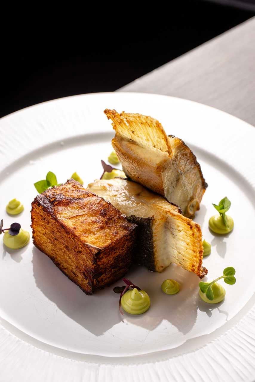 Close-up of a fish and vegetables meal served in EMME Restaurant at Margutta 19