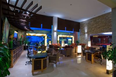 Foto del hotel Sunset Plaza Beach Resort tomadas en el vestíbulo con decoración moderna, asientos mullidos y grandes ventanales con una serena vista nocturna de palmeras