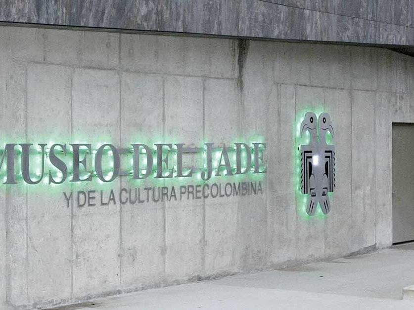 Entrance of the Museo del Jade, featuring illuminated signage on a concrete wall near D Sabana Hotel