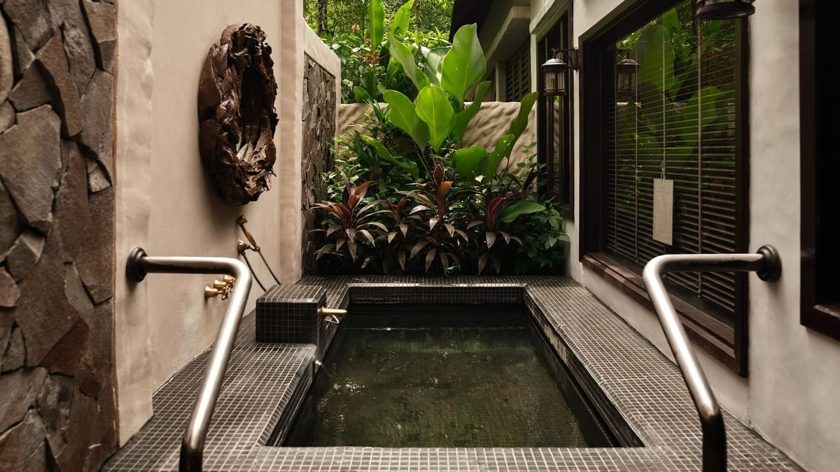 Outdoor hot spring jacuzzi with lush greenery in Garden Villa at The Banjaran Hotsprings Retreat