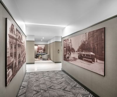 Modern hallway with vintage sepia photos of historical architecture on walls at Amora Herencia Riverwalk Melbourne