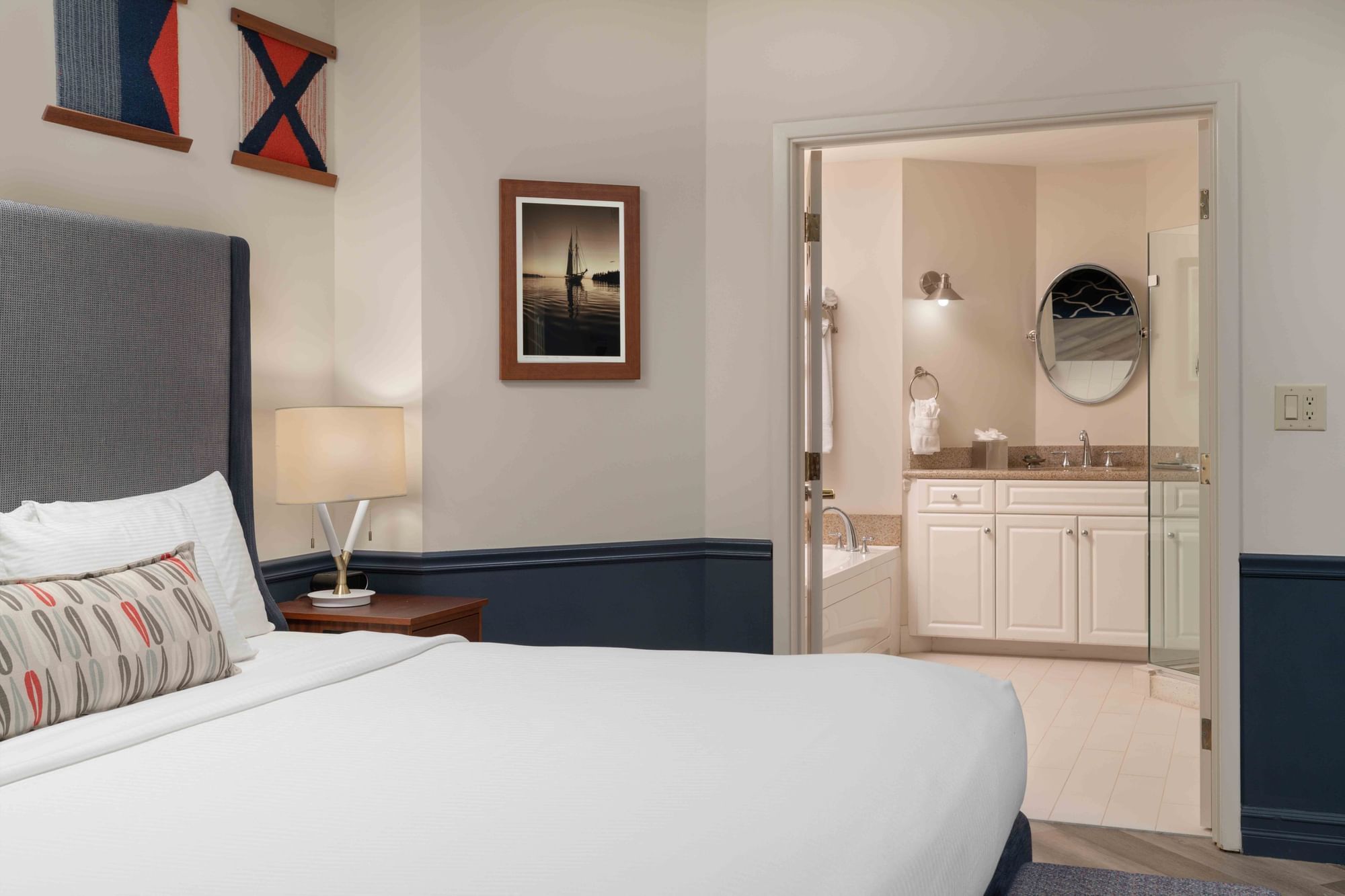 Whirlpool Spa Suite with cozy bed and an open door leading to the bathroom at Portland Harbor Hotel