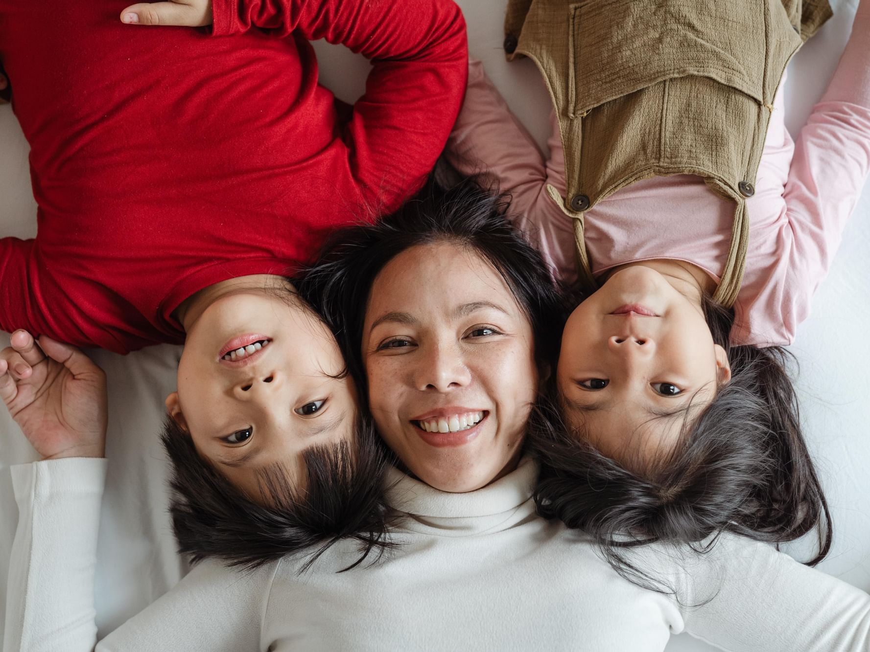 Mother and kids snuggled on the bed at Paradox Singapore