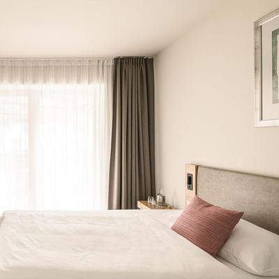 Bed & closet in Single Room Comfort at Falkensteiner Hotels