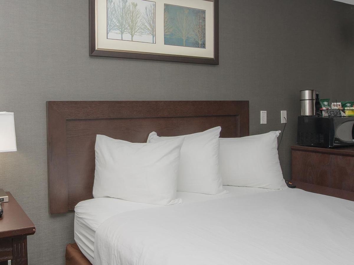 A bed with three white pillows.