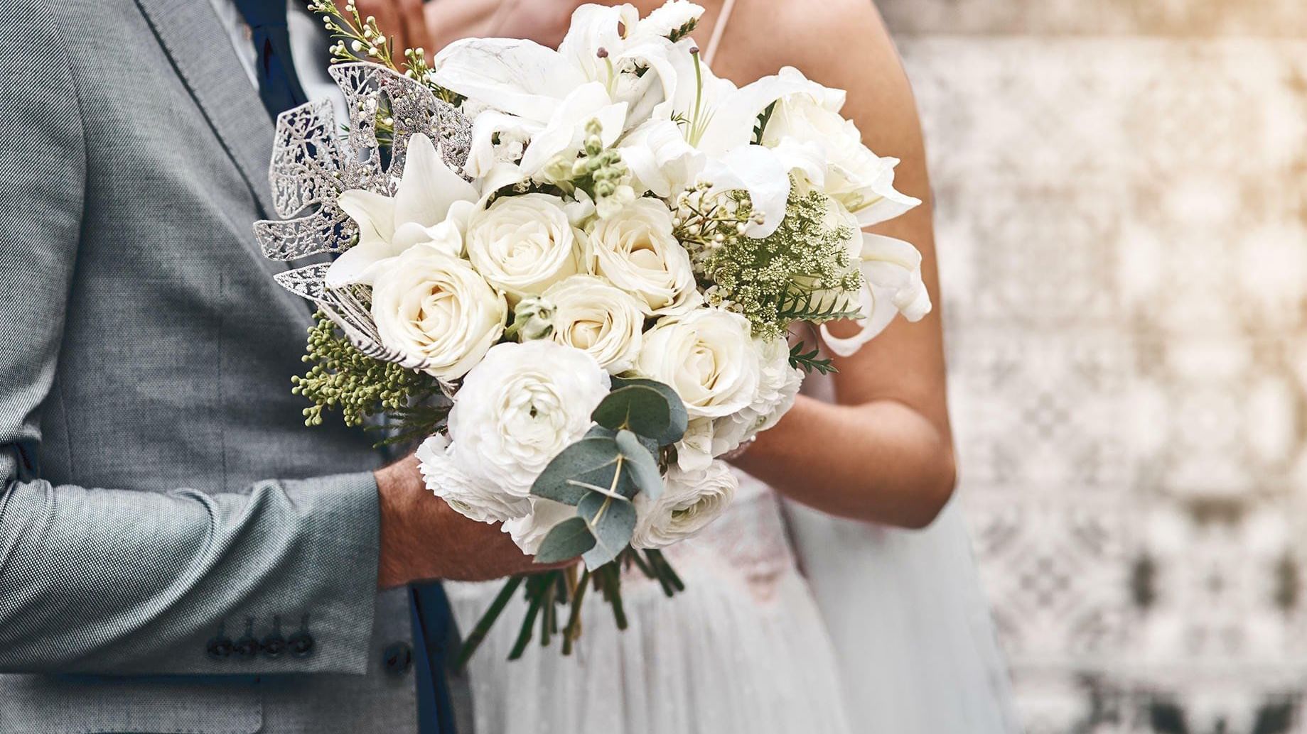 Bride & groom holding flower bouquet at Grand Fiesta Americana