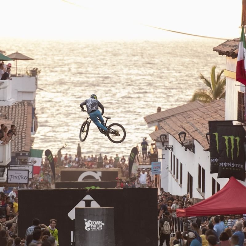 BMX rider performing a jump over obstacles at Puerto Vallarta Downhill 2026 event.