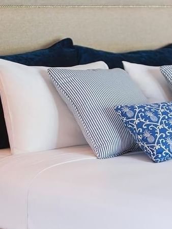 Elegantly decorated bed with blue and white pillows in the Efate Pool Villa at Warwick Le Lagon Vanuatu.