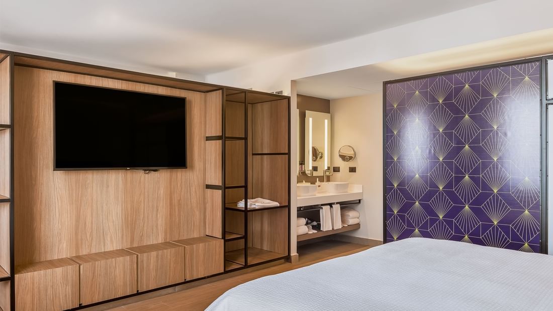 TV & vanity mirror facing a bed in Junior Suite, 1 King in a Room at Fiesta Inn Hotels