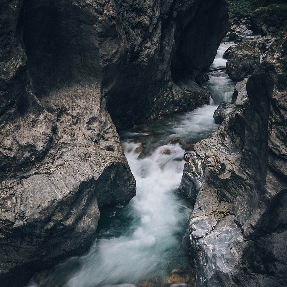 A river flowing through rocks in Vipiteno, Falkensteiner Hotels