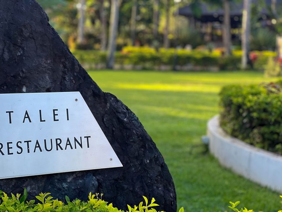 Sign for Talei Restaurant on rock in lush garden setting at The Naviti Resort Fiji.