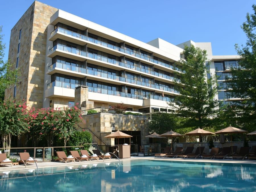Exterior view of the hotel & the outside pool with lounge chairs at Umstead Hotel and Spa