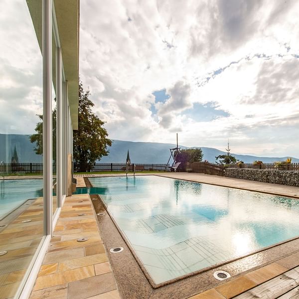 Pool area with mountain view at Falkensteiner Hotels