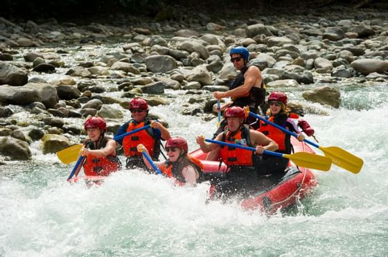 Group of people enjoying a rafting adventure on a river near Blackcomb Springs Suites