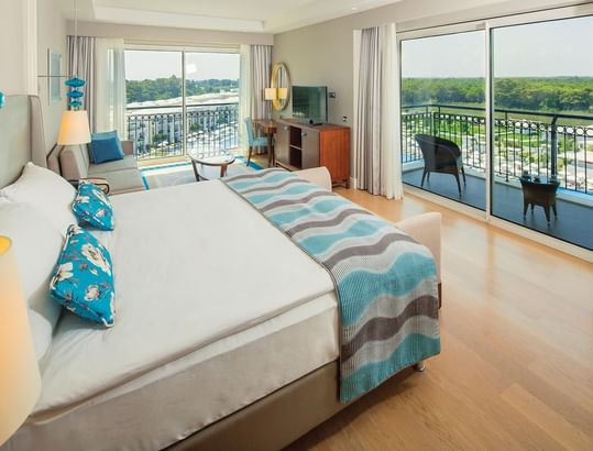 TV lounge area by the bed in Corner Suite with balcony view at Titanic Deluxe Golf Belek