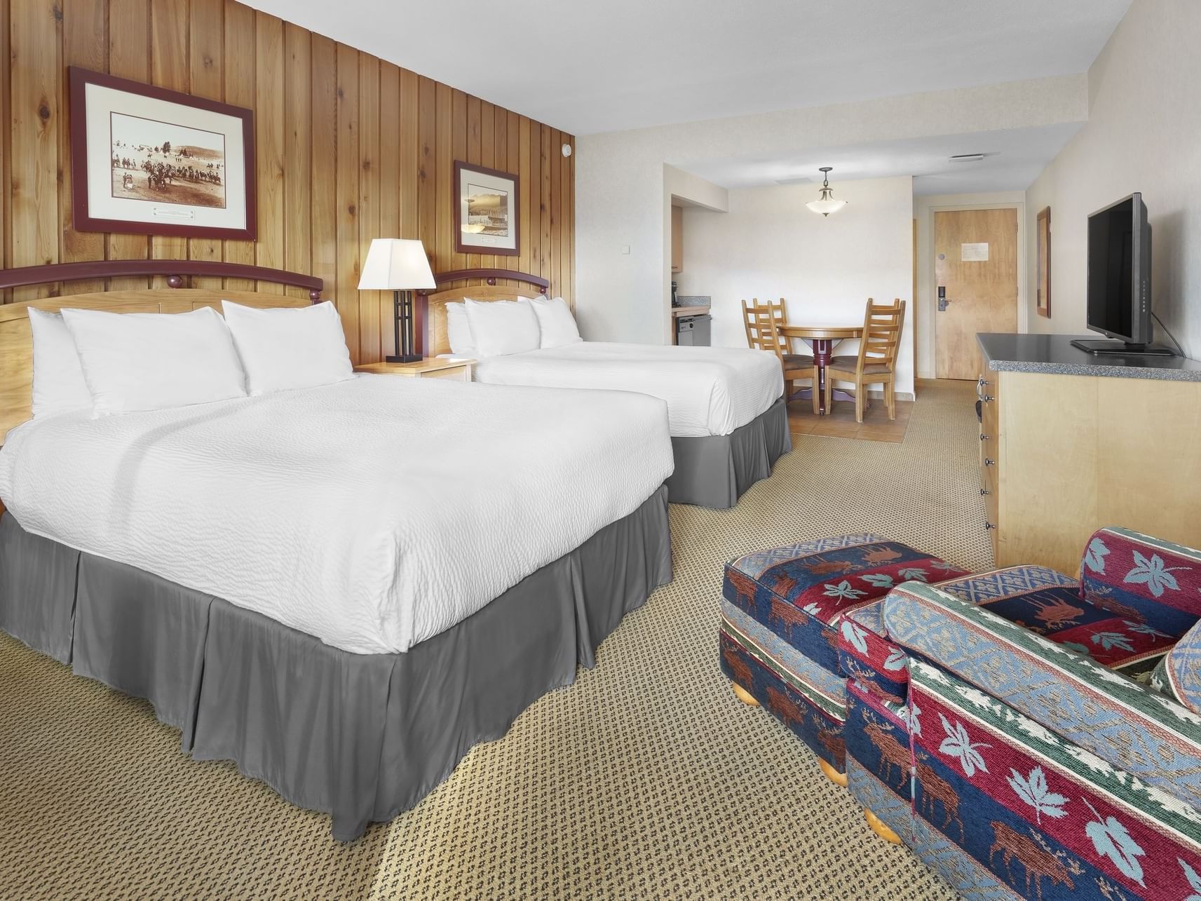 Beds, chair and TV in Pool Facing 2 Queen with Kitchenette at Fairmont Hot Springs Resort