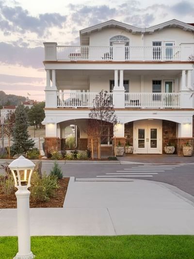 A white three-story building with a covered entrance and multiple balconies at The Stanley Hotel