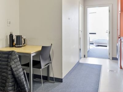 Small room with table, chair, and open door leading to another room at UniLodge Stafford House.