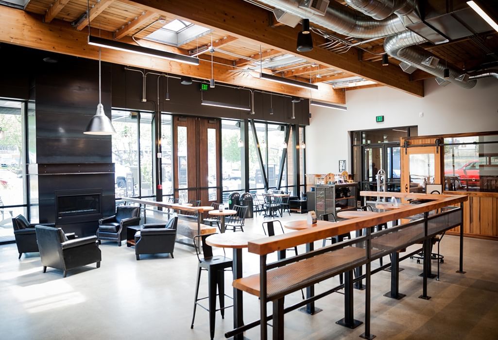 interior of Woods Coffee with lots of warm wood, couches, fireplace, and tables