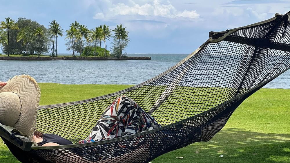 Relaxed person on a hammock by the beach at The Naviti Resort in Korolevu.