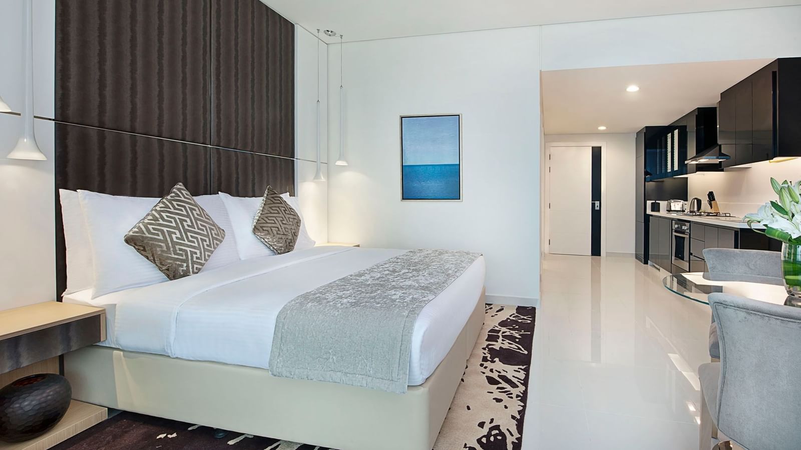 King-sized bed and fully equipped kitchen in Deluxe Room at DAMAC Maison Canal Views